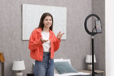 Smiling teenage blogger explaining something while streaming at home