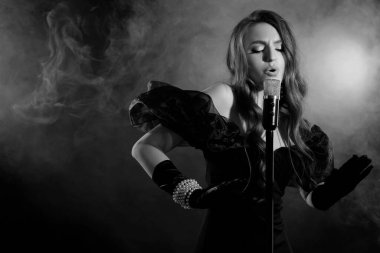 Mikrofonlu güzel bir şarkıcı, siyah beyaz efektli.