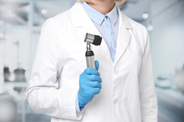 Professional dermatologist with dermatoscope on blurred background, closeup clipart