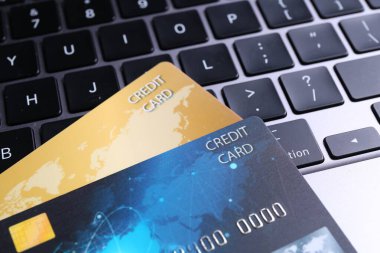 Dizüstü bilgisayarda iki plastik kredi kartı, yakın plan.