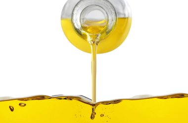 Beyaz arka planda sürahide pişirme yağı dökülüyor, yakın plan