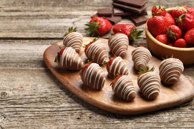 Delicious chocolate covered strawberries on wooden table. Space for text
