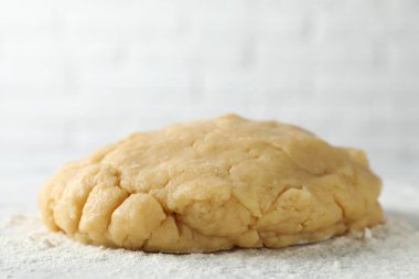 Kısa hamur işi yapıyorum. Çiğ hamur ve un masaya, yakın plan.