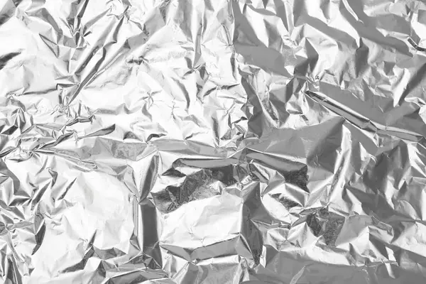 stock image Crumpled silver foil as background, top view