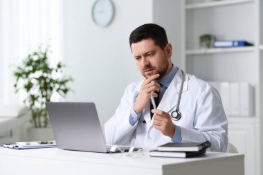 Doktorun klinikteki masada dizüstü bilgisayarla danışması