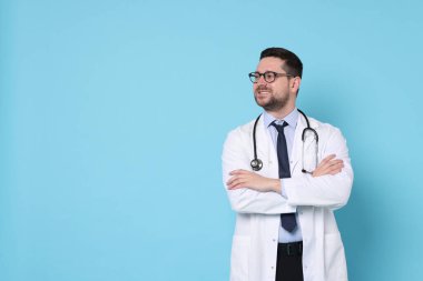 Açık mavi arka planda gülümseyen doktor, metin için boşluk