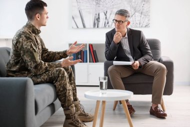 Professional psychotherapist working with military man in office