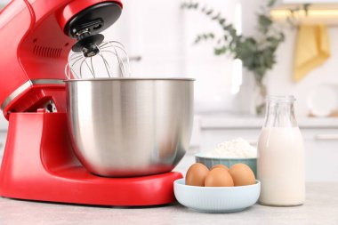 Modern kırmızı stand mikseri ve ürünler açık gri mutfak masasında