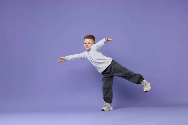 Stock image Happy little boy dancing on violet background