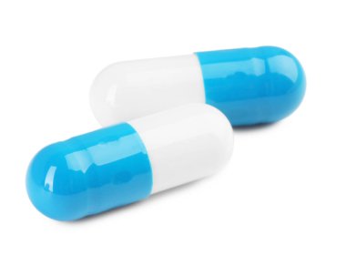 Beyaza izole edilmiş iki antibiyotik hapı. Tıbbi tedavi