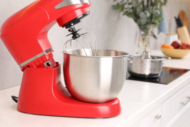 Mutfaktaki beyaz tezgahta modern kırmızı stand mikseri.
