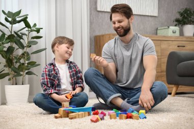 Happy dad and son playing with cubes at home