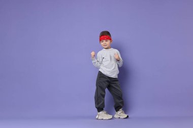 Mutlu küçük çocuk menekşe arka planda dans ediyor