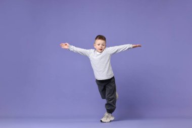 Mutlu küçük çocuk menekşe arka planda dans ediyor