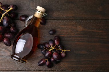 Şarap sirkeli sürahi ve ahşap masada üzümler, düz yatak. Metin için boşluk