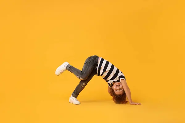 stock image Happy little boy dancing on yellow background. Space for text