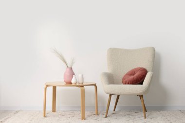 Rahat koltuk, yastık, sehpa ve dekorasyon.