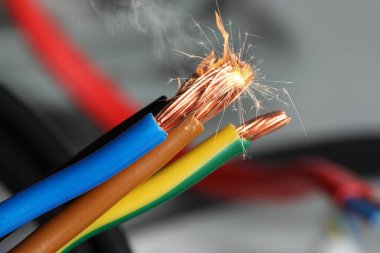 Arkaplanda kıvılcım saçan kablolar, yakın plan görünümü