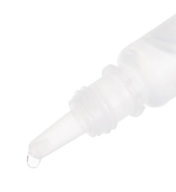 Beyaz arka planda şişeden damlayan tıbbi damlalar