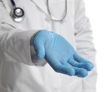 Açık mavi eldivenli doktor beyaz arka planda bir şey tutuyor, yakın plan.