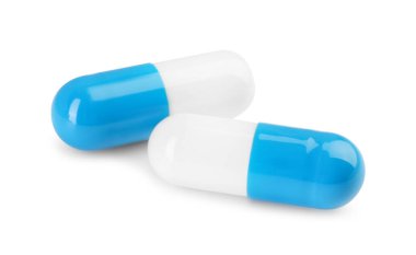 Beyaza izole edilmiş iki antibiyotik hapı. Tıbbi tedavi