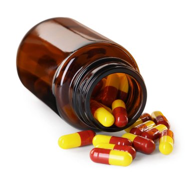 Dağılmış antibiyotik hapları ve beyaz şişeye izole edilmiş şişe.