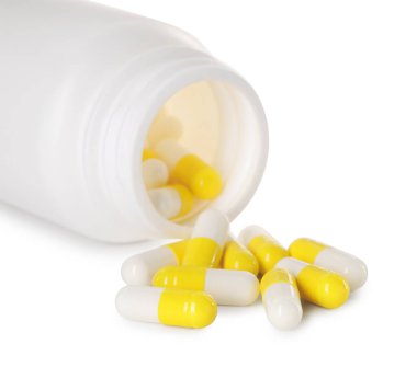 Dağılmış antibiyotik hapları ve beyaz şişeye izole edilmiş şişe.