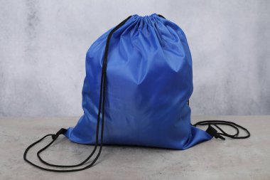 Gri desenli masada mavi çizgili çanta