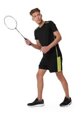 Beyaz arka planda raketle badminton oynayan genç adam.