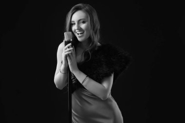 Mikrofonlu güzel bir şarkıcı, siyah beyaz efektli.