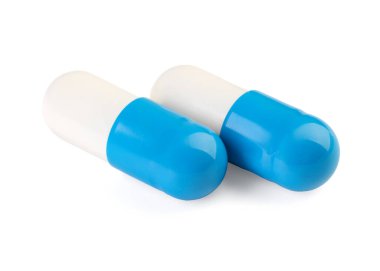 Beyaza izole edilmiş iki antibiyotik hapı. Tıbbi tedavi