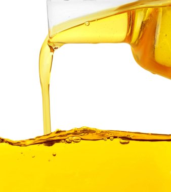 Beyaz arka planda sürahide pişirme yağı dökülüyor, yakın plan