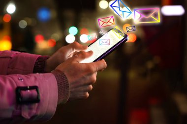 Akıllı telefonlu bir adam dışarıda sohbet ediyor, yakın plan. Gelen iletiler aygıtın dışından gelen birçok zarf çizimi