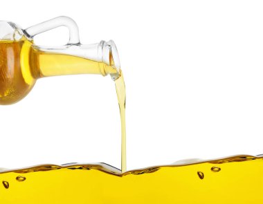 Beyaz arka planda sürahide pişirme yağı dökülüyor, yakın plan