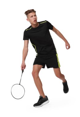 Beyaz arka planda raketle badminton oynayan genç adam.