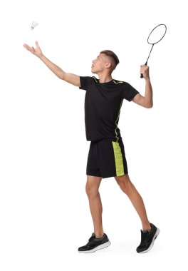 Beyaz arka planda raketle badminton oynayan genç adam.