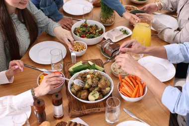 Ahşap masada vejetaryen yemekleri yiyen arkadaşlar, yakın plan.