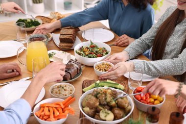 Ahşap masada vejetaryen yemekleri yiyen arkadaşlar, yakın plan.