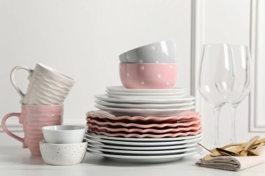 Güzel seramik bulaşık takımı, bardaklar, bardaklar ve çatal bıçak takımı beyaz mermer masa üzerinde.