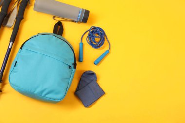 Sarı arka planda farklı spor aletleri, düz yatış. Metin için boşluk