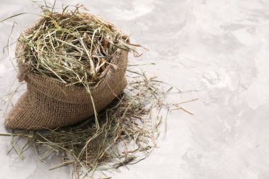 Açık gri desenli masanın üzerinde, çuval içinde kurumuş saman. Metin için boşluk