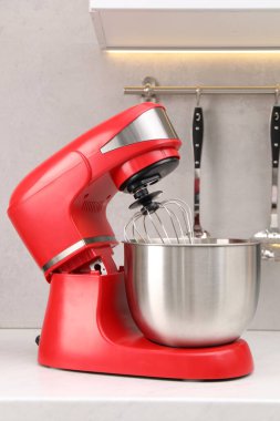 Mutfaktaki beyaz masada modern kırmızı stand mikseri.