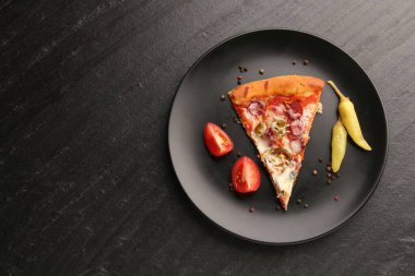 Lezzetli pizza, Diablo, biber, domates ve biberli tabak koyu dokulu masa, üst manzara. Metin için boşluk
