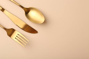 Bej masaya serilmiş şık çatal bıçak seti. Metin için boşluk