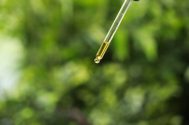 Pipetten gerekli yağı damlatıyor, yakın plan.