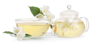 Cam bardakta Aromatik bitki çayı, çaydanlık ve beyaz üzerine izole edilmiş çiçekler.