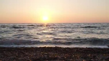 Gün batımında sahilde çıplak ayakla yürüyen kadın, yakın plan.