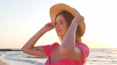 Güneş batarken hasır şapka takan güzel bir kadın. Kamera hareket ediyor kızım.