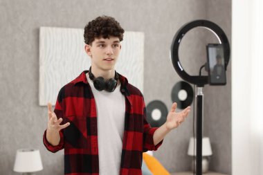 Teenage blogger explaining something while streaming at home