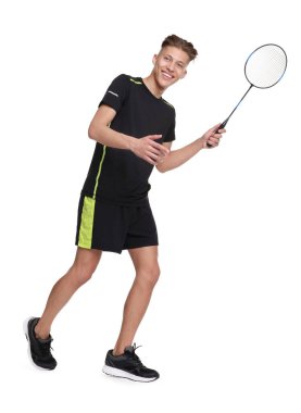 Beyaz arka planda raketle badminton oynayan genç adam.